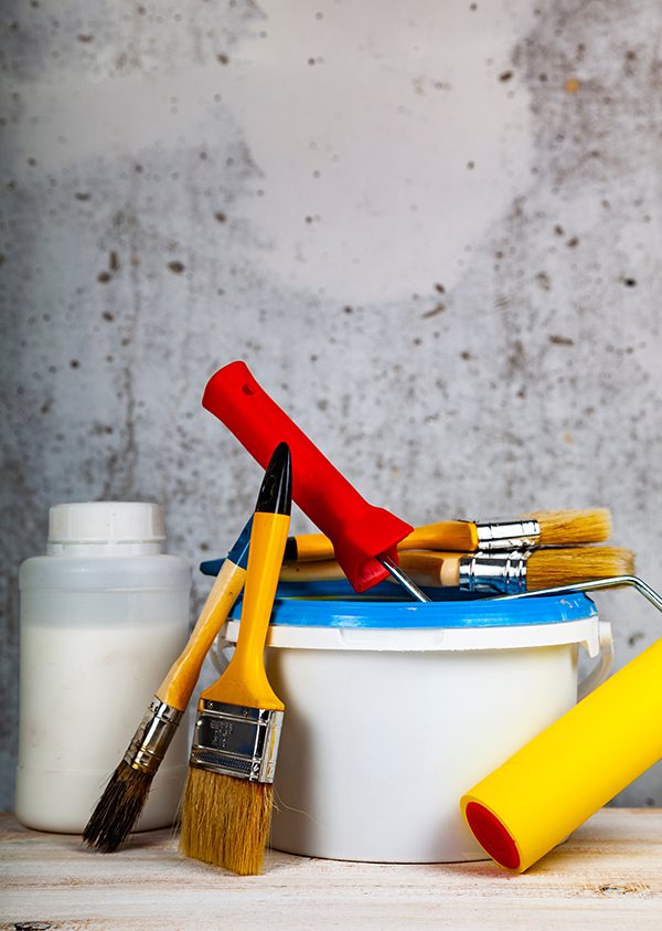 Paint can, roller and brush on the table. Paint can, roller and brush on the table. Items for home or office renovation on gray background.