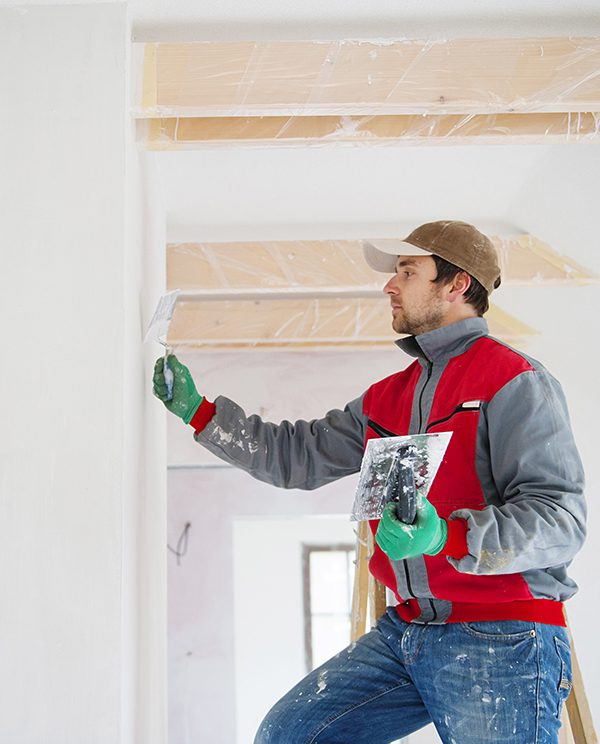 25c7364f-097c-4ae7-89dd-0136a87e54ea Construction worker is painting the wall in new house